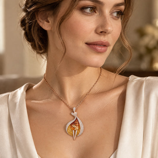 A woman wearing a delicate gold chain necklace with a teardrop-shaped pendant featuring a white crystal border and a central yellow-gold and orange enamel design.